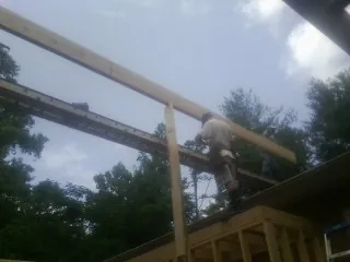 Carpenter setting a ridge beam over a new addition frame — Ice Dam Removal by Roofing Brothers in Plainville